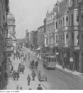 Fragment ulicy Królowej Jadwigi - Fragment ulicy Królowej Jadwigi z widocznym tramwajem, bryczką zaprzężoną w konie, witrynami i szyldami sklepów. Zdjęcie wykonane w latach 1918 - 1937.