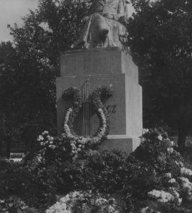 Widok ogólny pomnika przystrojonego kwiatami.  - Fotografia pochodzi z lat 1930 - 1939.
